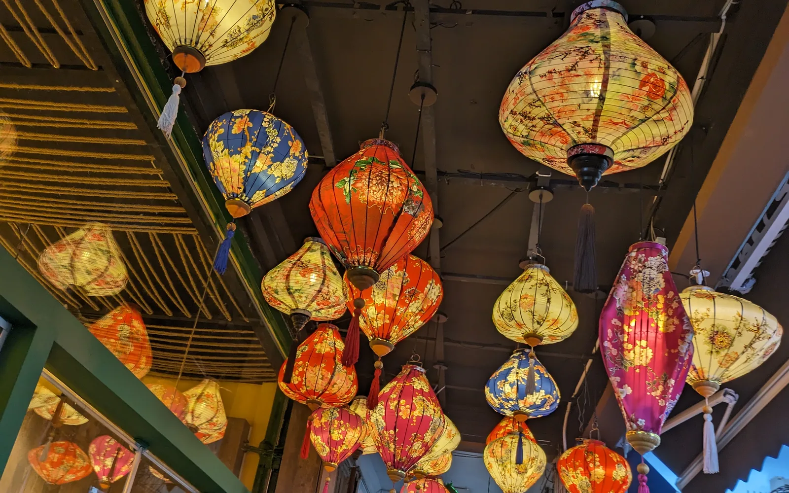 Vibrant Vietnamese lantern decorations strung across a street in a community area, illuminated and celebrating Vietnamese cultural traditions
