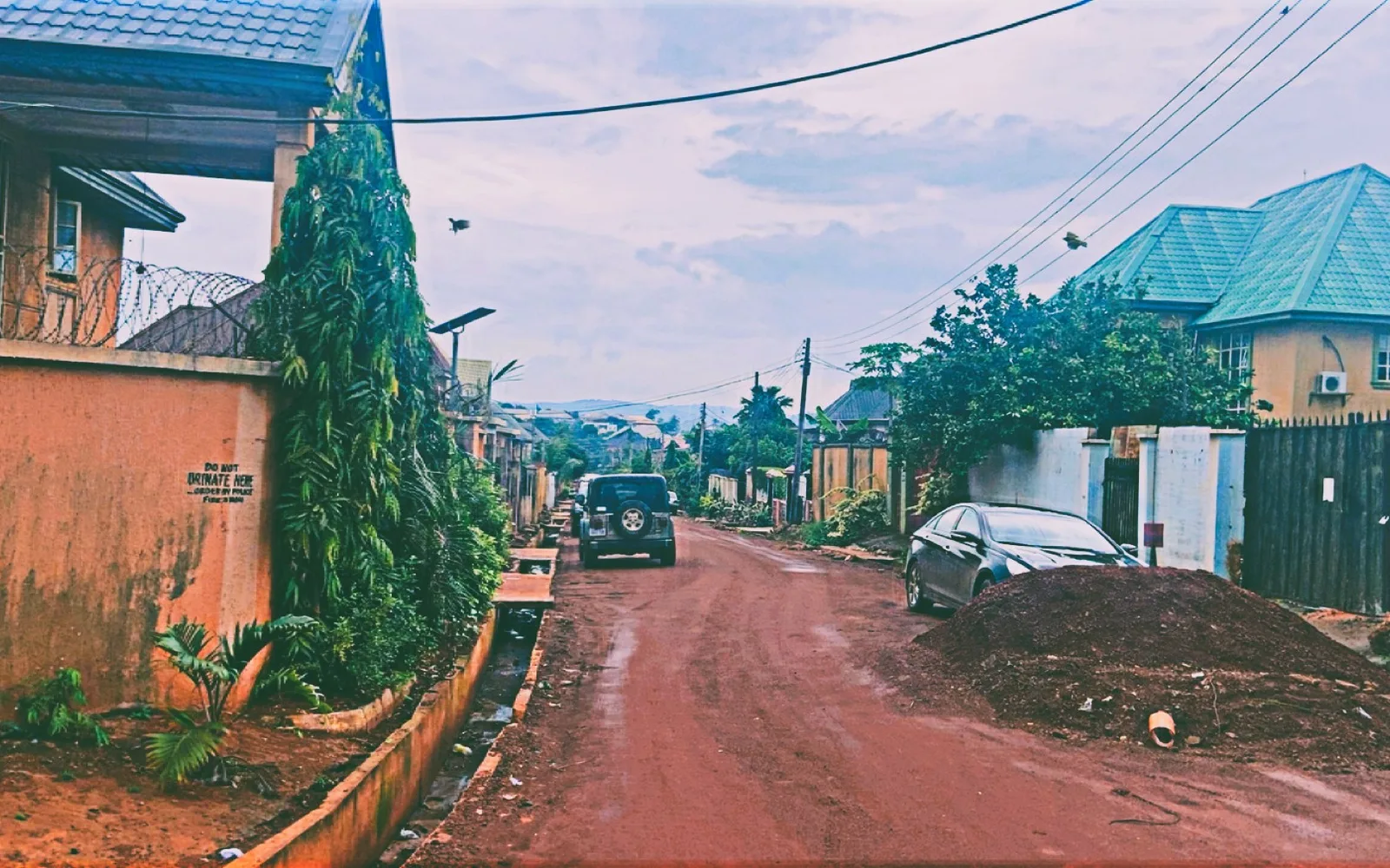 A quiet residential street lined with houses and community infrastructure, representing typical suburban neighborhood living
